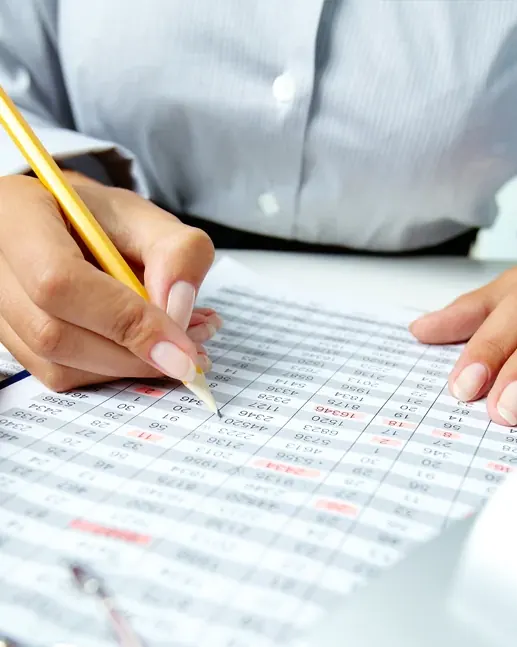 Registro contable a mano sobre una planilla con calculadora