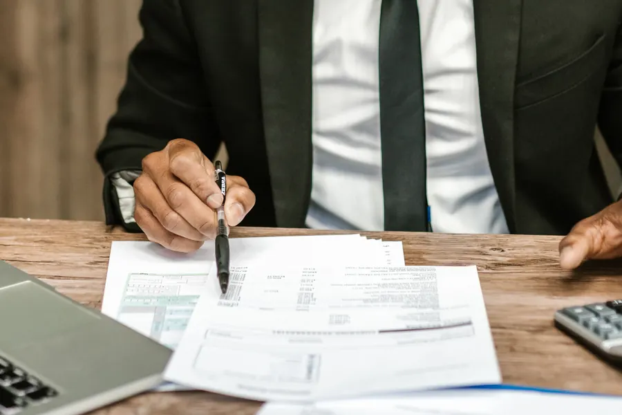 Ambiente de trabajo de un despacho contable, revisando documentos en el escritorio